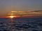 The setting sun, clouds and a lone gull