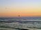 Gulls flying across the beautiful early evening sky above the breaking waves.
